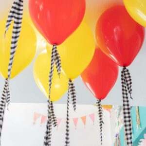 Globos con helio de España en rojo y amarillo descorados con cinta de tela vichy.