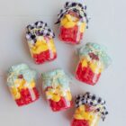 Tarritos de chuches España decorados con tela vichy y rellenos de gominolas rojas y amarillas.