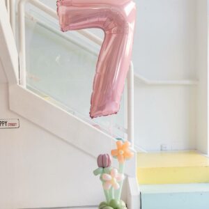 Centro floral con número de helio y base orgánica de globos para decoración de cumpleaños